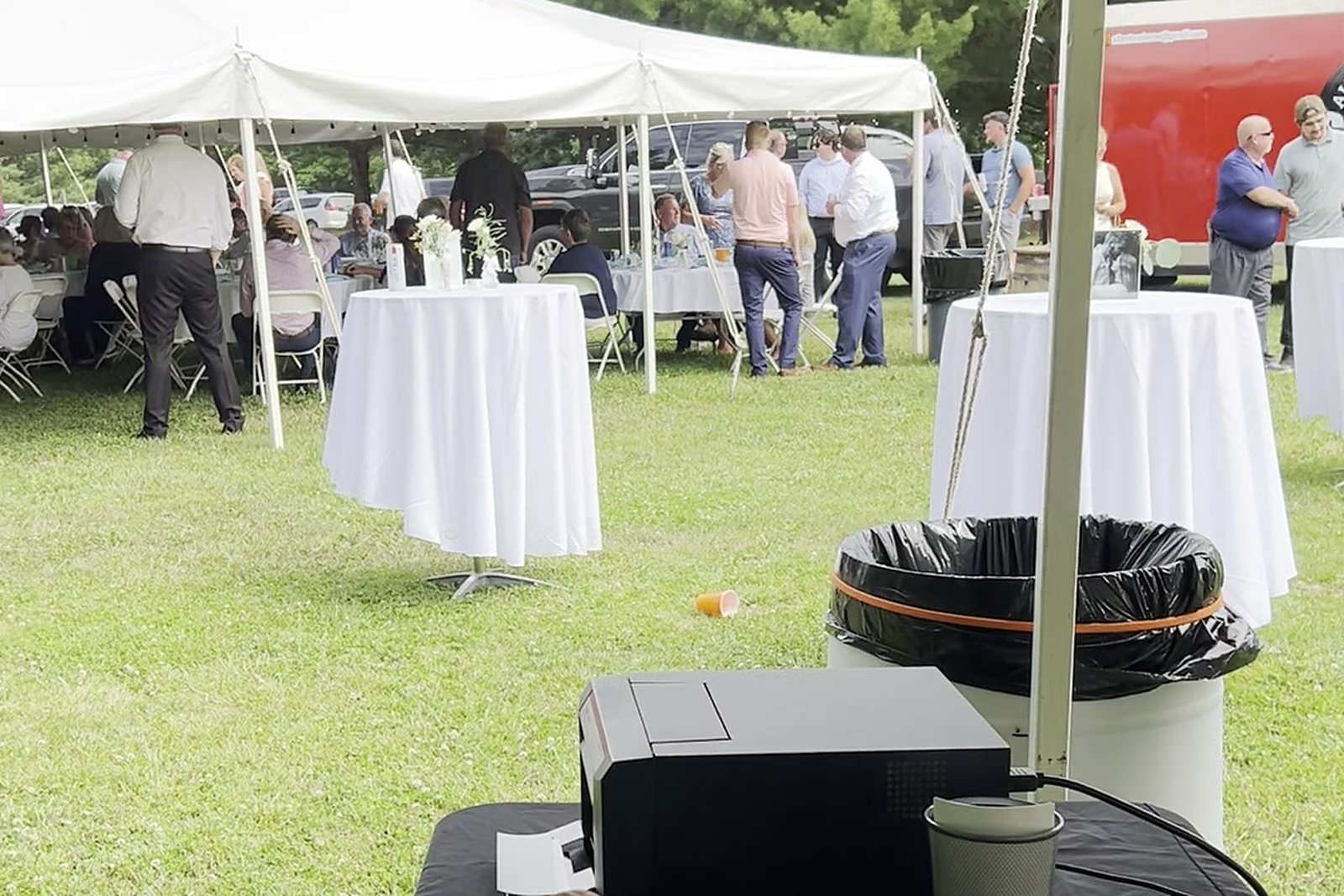 Guests mingling under an outdoor festival tent at a photo booth rental near Morenci MI